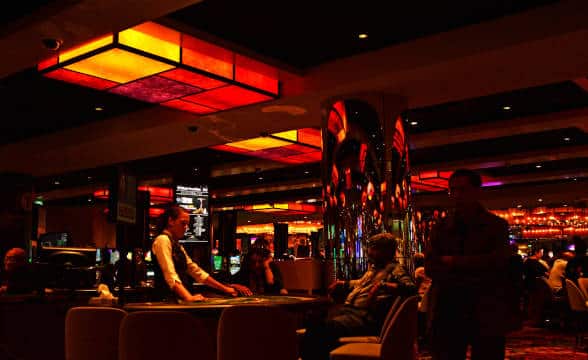 A lone casino worker sitting at a table and waiting for someone to join her table.