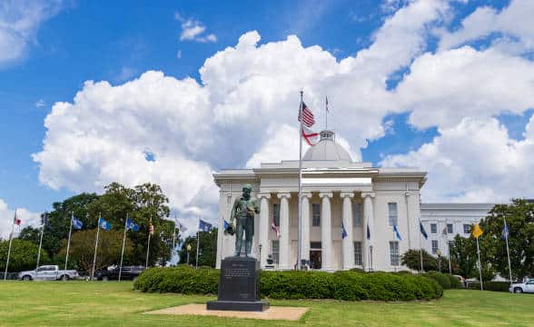 The official State Senate in Mongomery, Alabama. The photo is of the front building where a statue and the state flag can be seen.