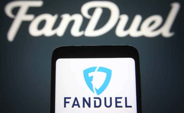 FanDuel mobile app on a smartphone against a background of FanDuel's logo.