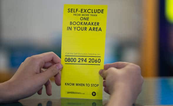 A GambleAware self-help slip held by someone.