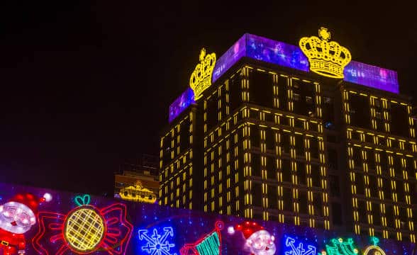 The Grand Emperor Hotel in Macau at night and lit in bright colors.