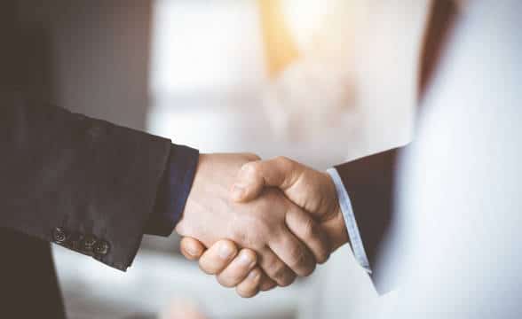 Two people shaking hands as sign of partnership.