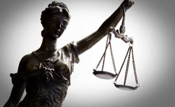 Lady Justice holding her scales up and wearing a blindfold.