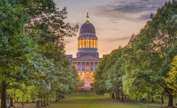 The Maine State House photographed from the park during dusk.