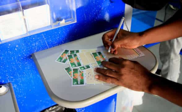 Mega Sena lottery ticket being filled out by a person.