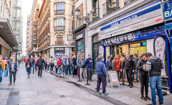 Lottery venue in Spain with people filing up to buy a lottery ticket.