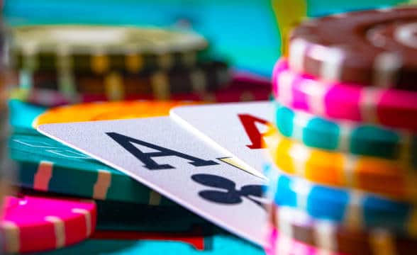 Poker table with chips and a game of poker in progress.