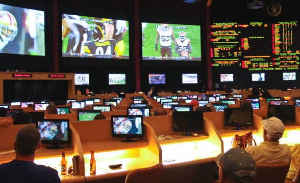 Sports bettors in a sports betting lounge and watching sports.