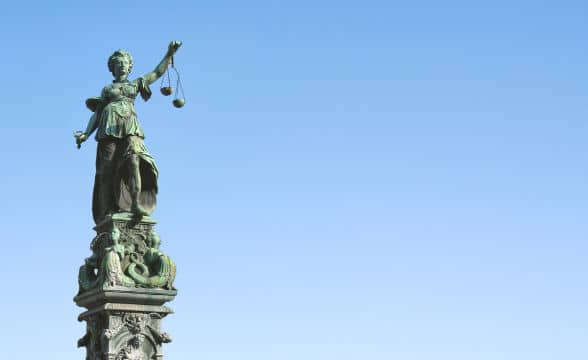 Statue of Lady Justice with her scales photographed from below.