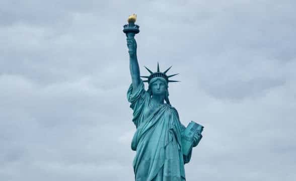 The Statue of Liberty in New York against a grey sky.