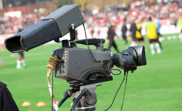 A TV camera on a football field.