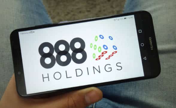 The 888 Holdings logo on a smartphone.