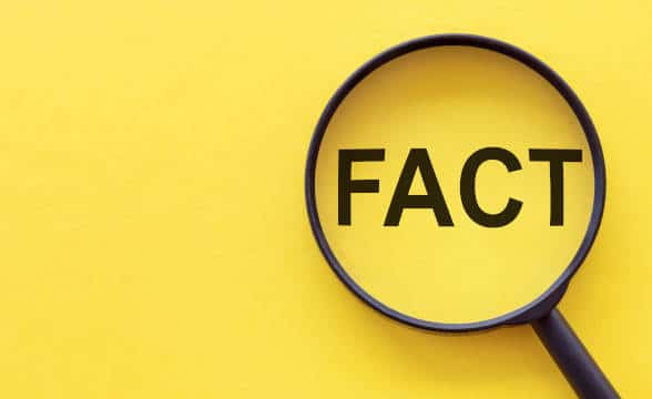 A magnifying glass that is magnifying the word "fact" on a yellow background.