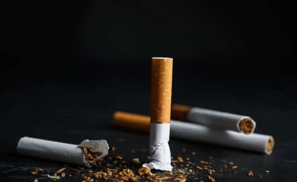 A stubbed out cigarette against a black backdrop.