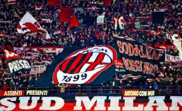 AC Milan's fans in a staidum with flags and team fanfare.