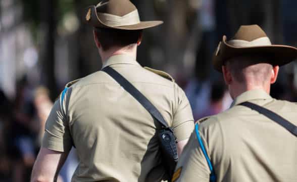 A pair of Australian soldiers walking downstreet.