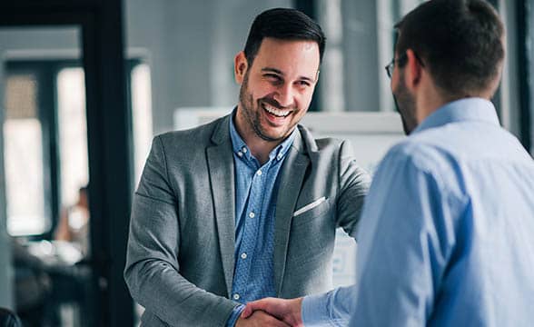 Two happy businessmen shake hands