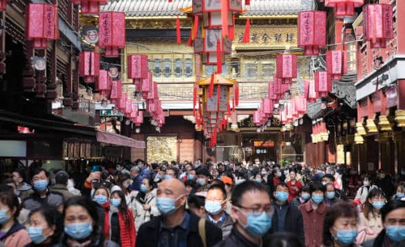 People in Shanghai walking around and wearing masks.