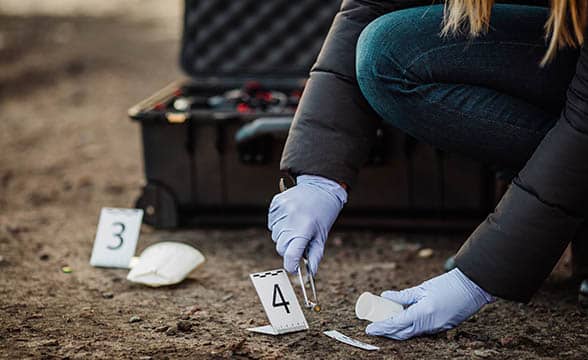 An investigator collects evidence at a crime scene