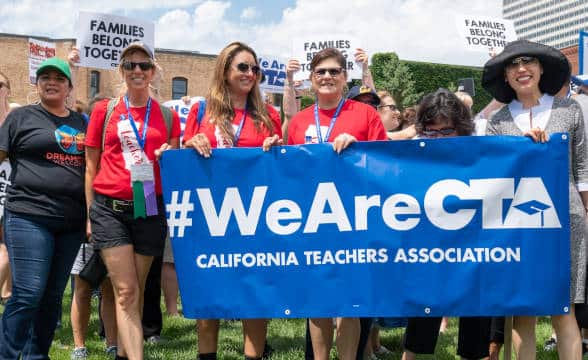 Members of the California Teachers Association holding a #WeAreCTA flag.