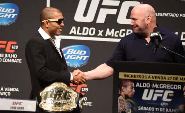 Dana White shaking hands with a UFC fighter.