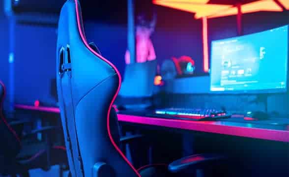 A PC with a gaming chair next to it