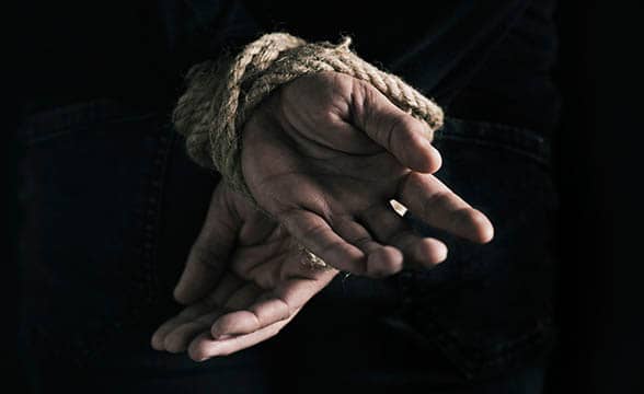 Tied hands of a person who's being held hostage