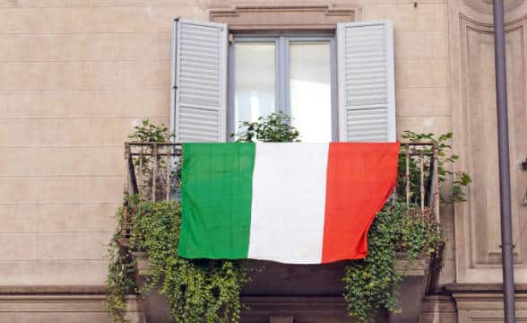 A balcony in Italy with the national flag on it.