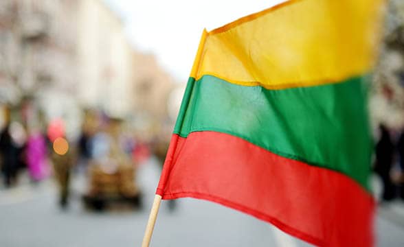 The flag of Lithuania is being waved on a street