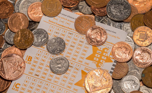 A bunch of British coins with a lottery ticket.