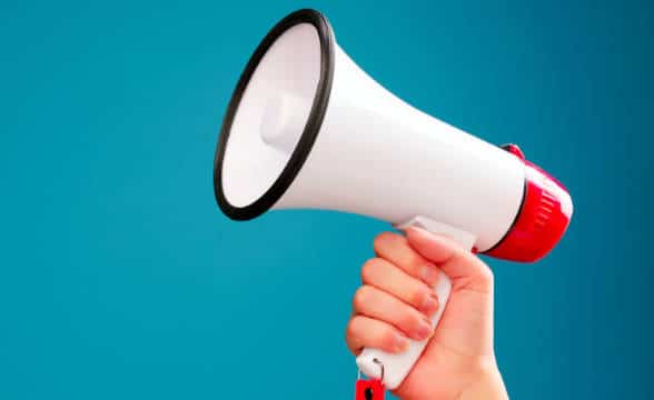 A loudspeaker held by a person in the air.