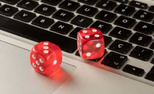 Online gambling with a pair of dice lying on a keyboard.