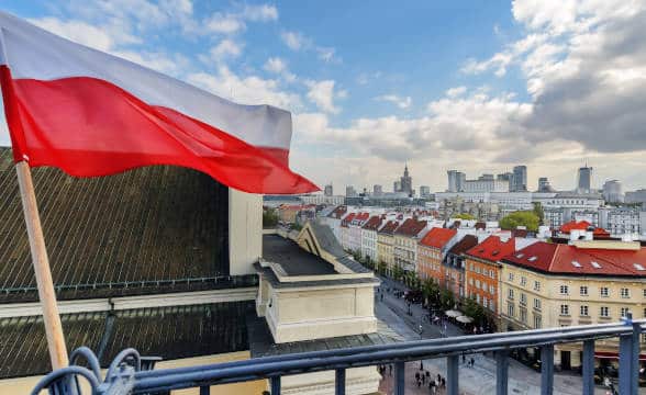 The Polish flag against a background of Warsaw's old town.