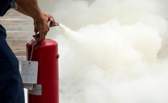 A man puts out a fire with a fire extinguisher