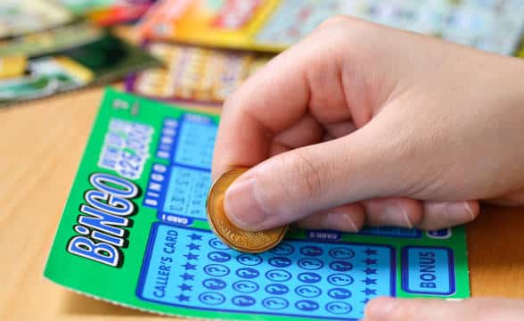 A person scratching off a bingo ticket.