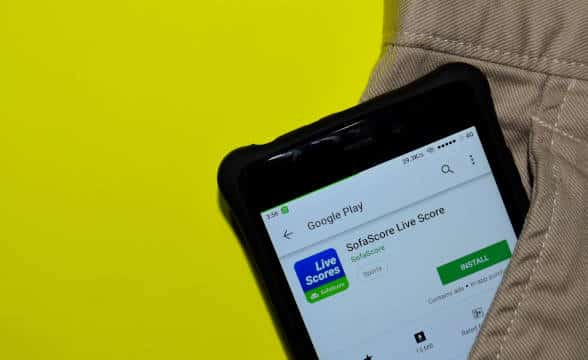 A SofaScore displayed on a smartphone that's in the backpocket of some individual.