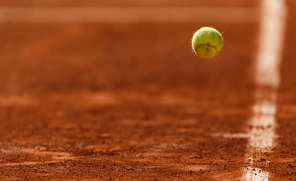 A tennis ball bouncing off the clay court.