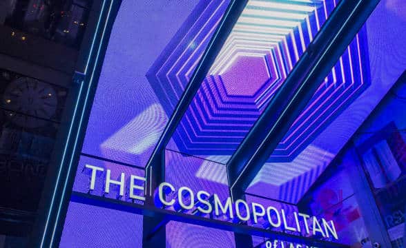 The Cosmopolitan of Las Vegas' entry sign lit in neon blue and purple colours.