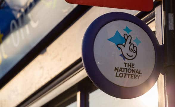 The UK National Lottery's logo operator by Camelot with the sign being put outside one of the outlets.