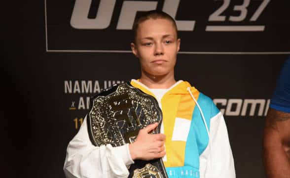 UFC fighter Rose Namajunas clasping her title.