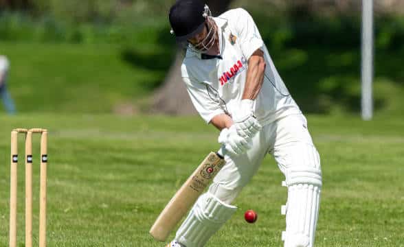 A cricket player taking a bat.