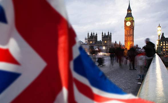 A person waves Britain's flag next to the Big Ben