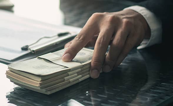 A businessman puts forward a stack of money