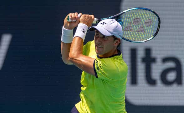 Casper Ruud playing tennis and just hitting away a ball.