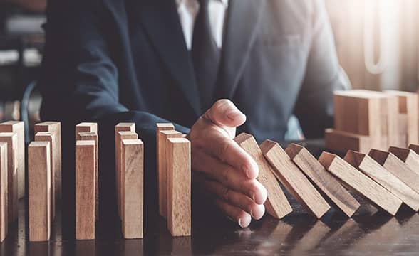 A businessman prevents blocks from falling