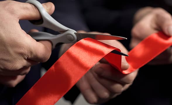 Person cuts a ribbon at an opening ceremony