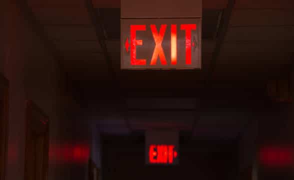 A hallway in a building with Exit signs.