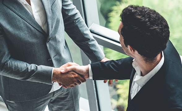 Two businessmen shake hands.