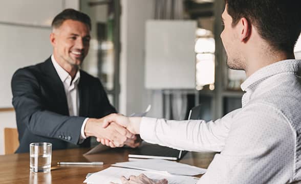 Businessmen happily shaking hands