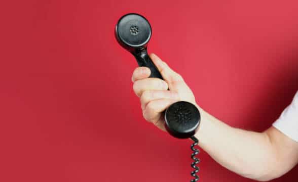 A phone line with a person holding the phone.